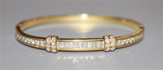 A 14k yellow metal, round and baguette cut diamond set hinged bangle, gross 14 grams.